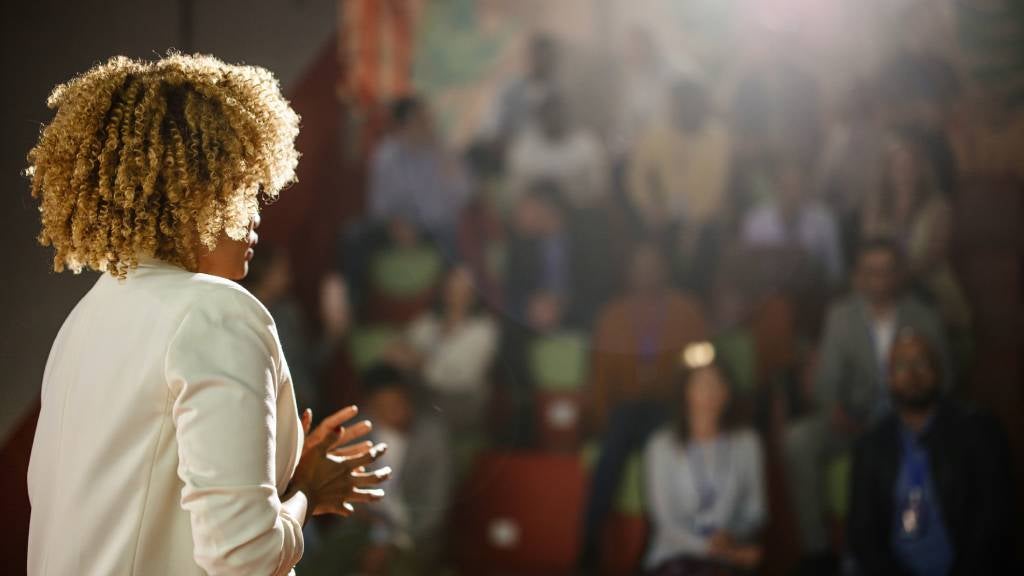 Woman giving a talk at conference event.