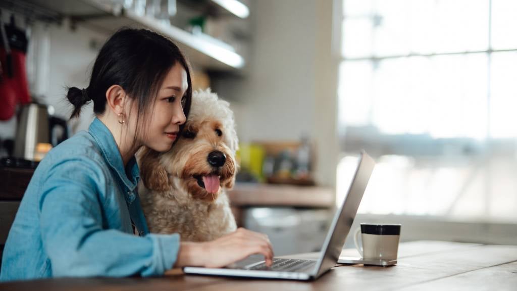 Young woman working from home with her dog