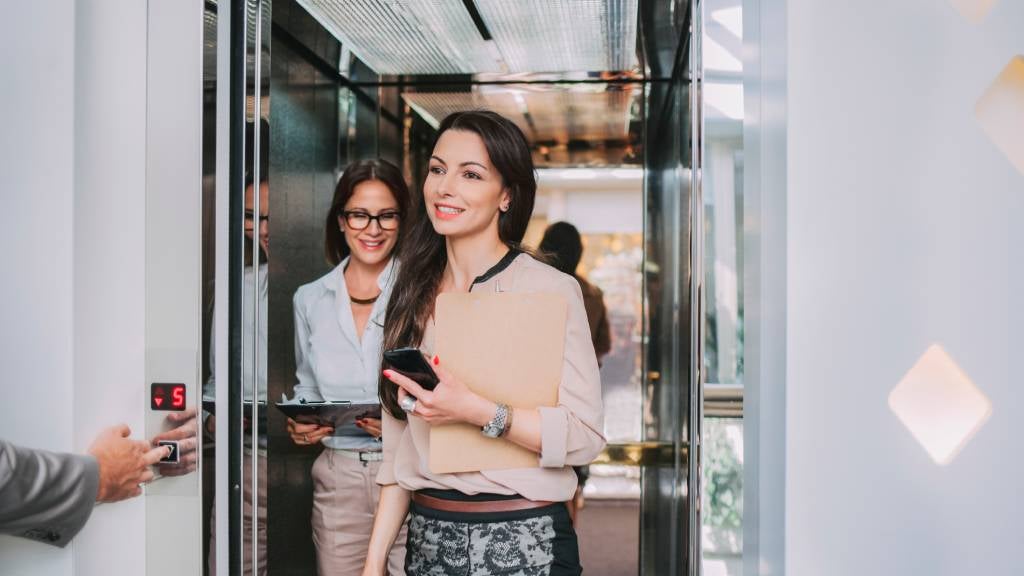 Businesswoman smiling as she walks out of an elevator