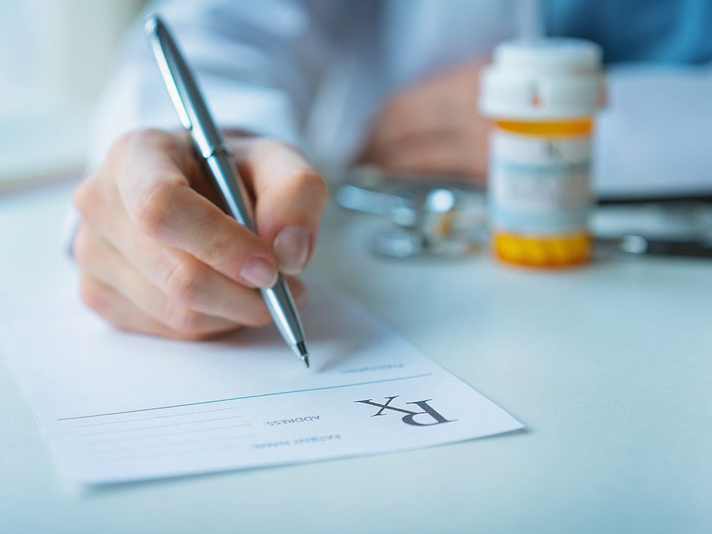 doctor writing prescription for drugs of dependence