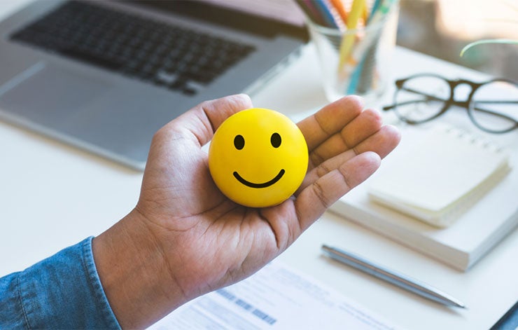 person holding a smiling stress ball