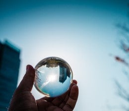 Person holding up glass ball to the sun