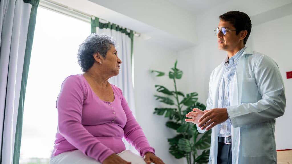Woman sits down in office talking to her doctor