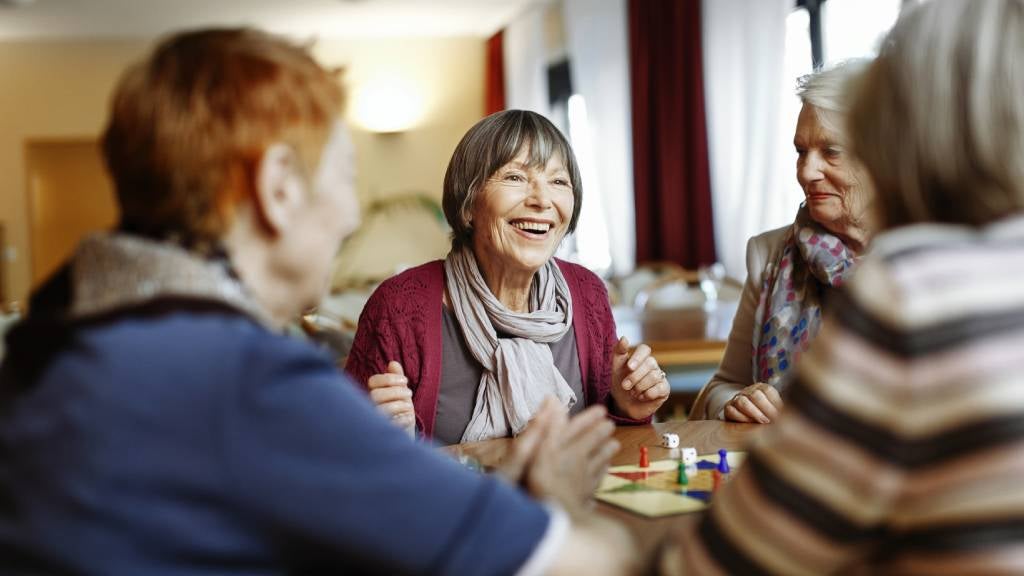 Group of senior woman in retirement village playing a board game