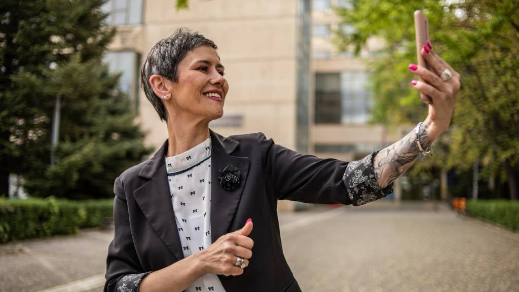 Senior woman looking at mobile phone smiling