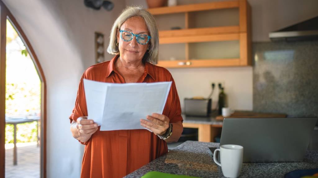 Women looking at printed documents in her kitchen