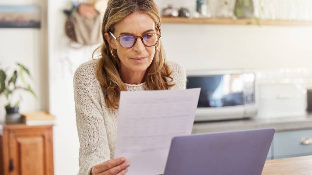 Senior woman with laptop and paperwork 