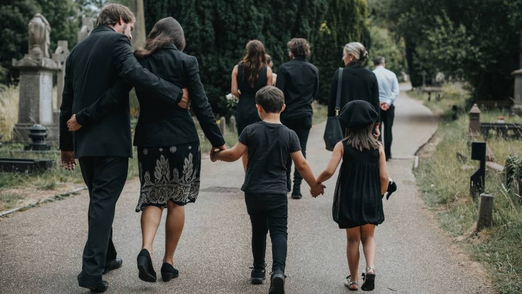 Family walk hand in hand after attending funeral