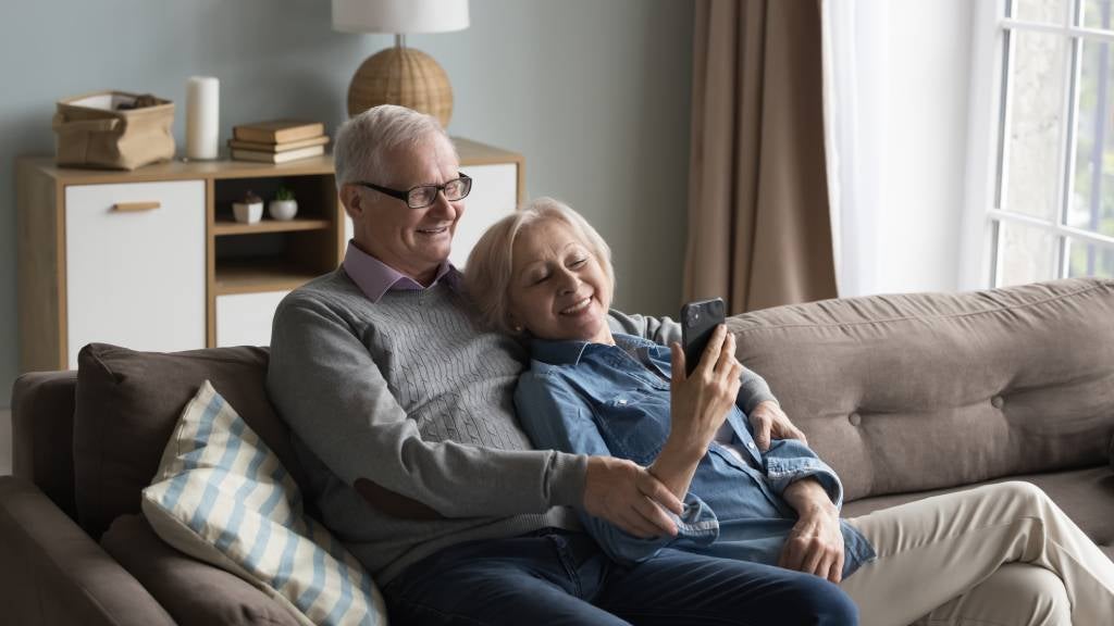 Senior couple looking at social media on mobile phone