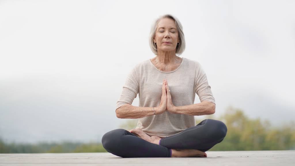 Senior woman meditating outdoors