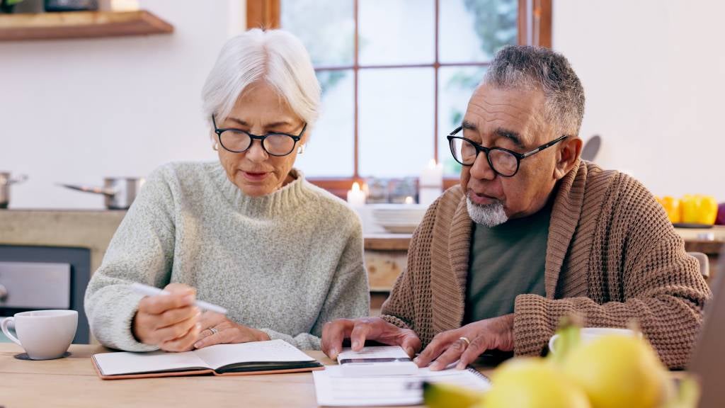 Senior couple writing their will on dining table 