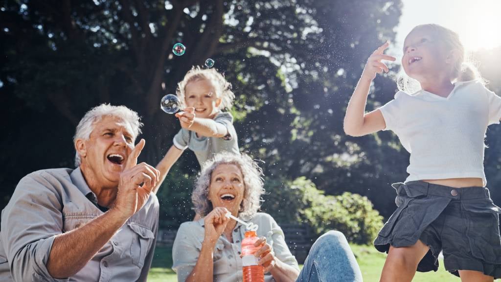 Grandparents and granddaughters playing with bubbles at the park