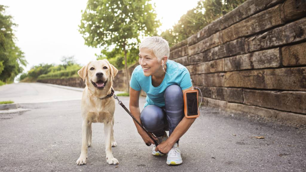 Retired woman exercising with golden retriever 