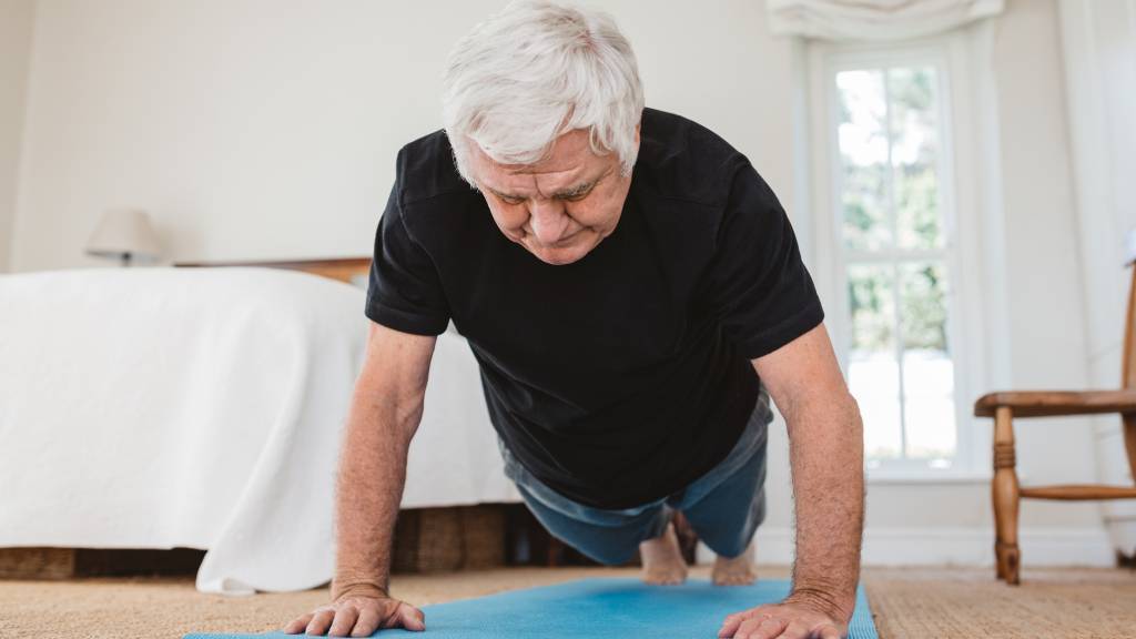 Senior man doing yoga at home 