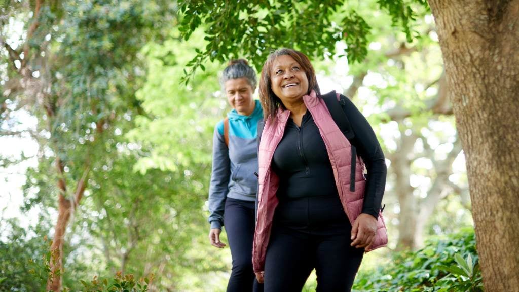 2 female friends walking outdoors.