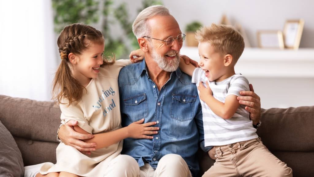 Happy grandfather hugging his grandchildren.