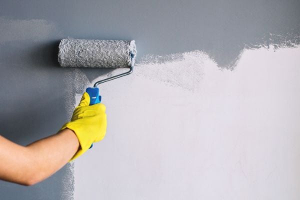 使用滾筒油漆刷在牆面塗灰色油漆