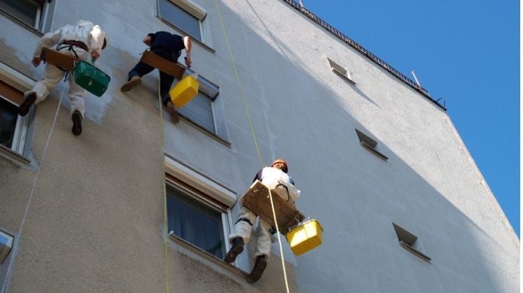 工人吊高為大樓進行防水工程