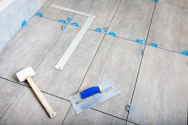 師傅會利用磁磚整平器與橡膠槌，加強地磚的平整度與密合度