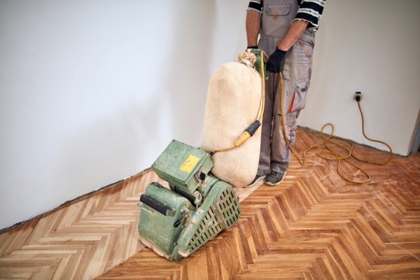 以裝有集塵袋的打磨機進行木地板打磨翻新