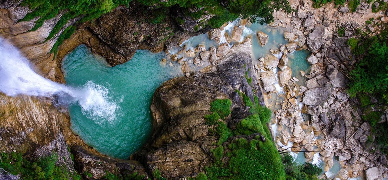 Waterfall falling into deep pool of water