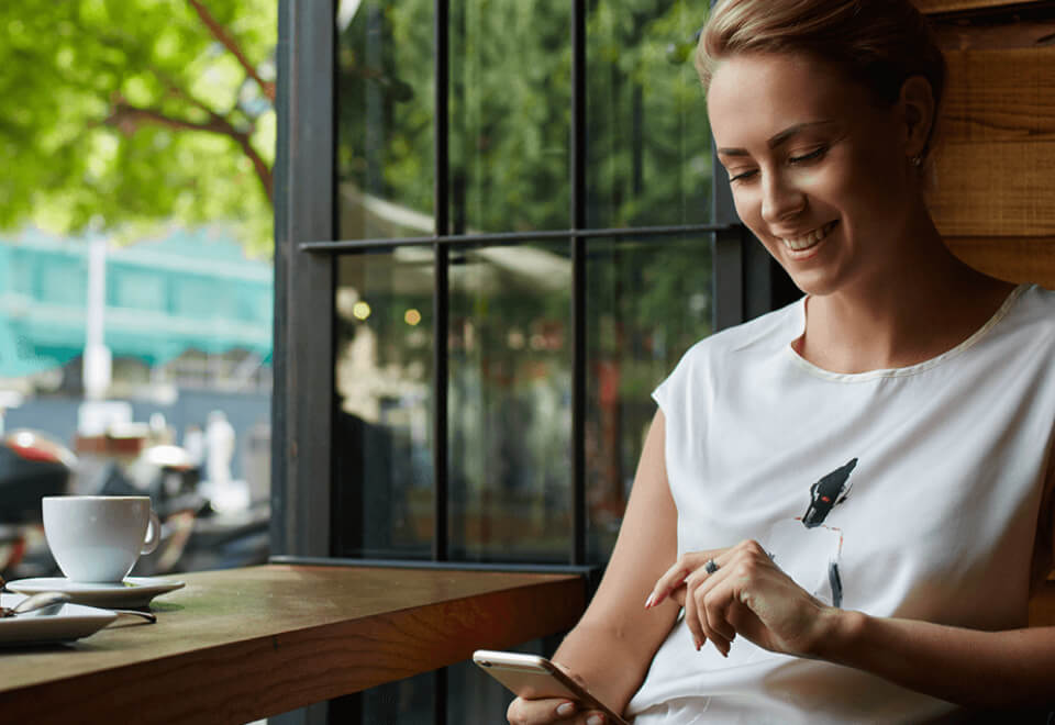 AHI | woman at cafe on phone | Devotion