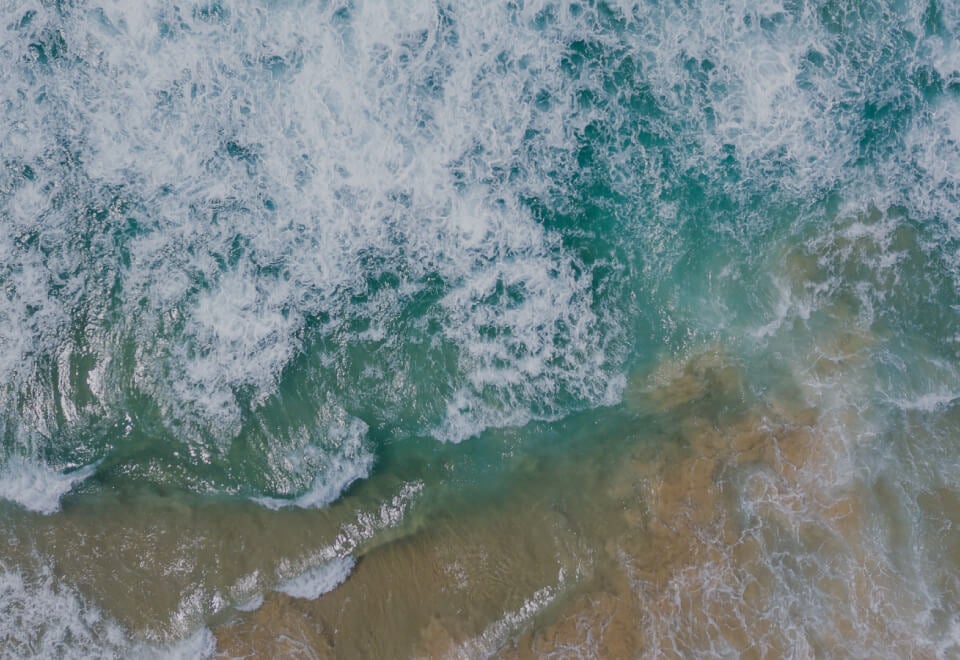 LGT Crestone | Waves crashing onto sand shown from above | Devotion