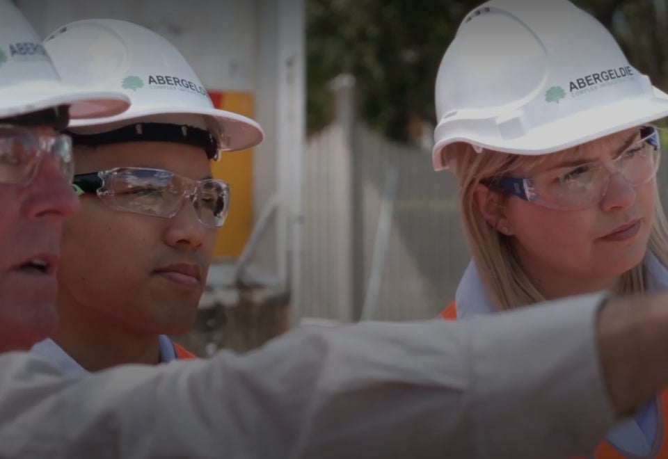 Abergeldie | A photograph of three Abergeldie project managers on site wearing hard hats and safety glasses | Devotion