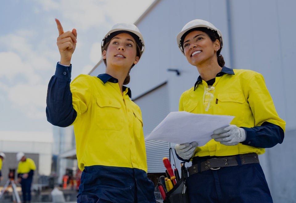 NECA | Two female electricians wearing high visibility clothing on a work site | Devotion