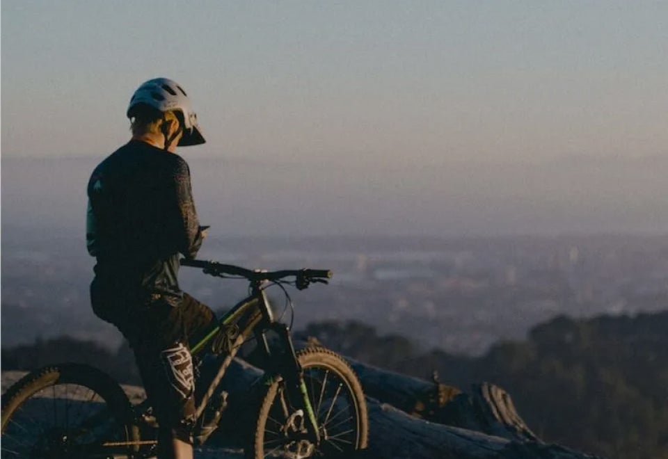 Flip Insurance | Mountain biker sitting at the top of a mountain at dusk waiting to commence their descent | Devotion