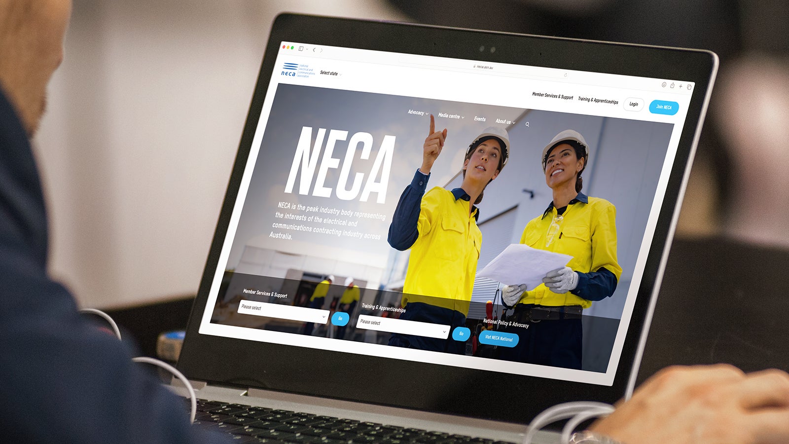 NECA | A laptop sitting on a desk being used by a man who is viewing the NECA website homepage | Devotion