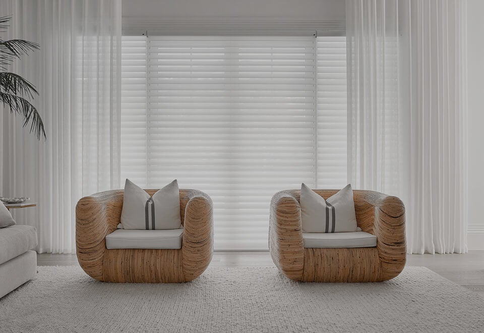 Luxaflex | Loungeroom setting with two chairs and Luxaflex blinks and soft window coverings | Devotion